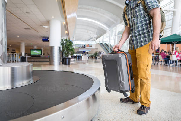 Traveler Unloading a Suitcase from a Luggage Carrousel