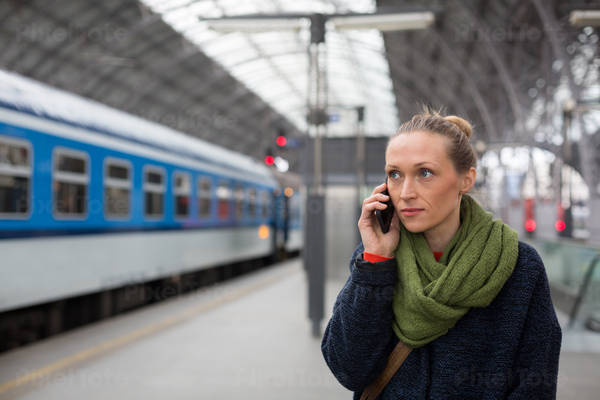 Woman Standing on a Train Station Platform and Making a Phone Call