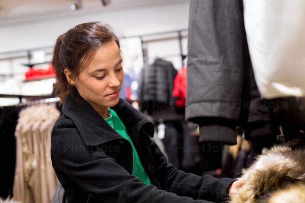 Girl Browsing a Clothing Rack in a Retail Shop