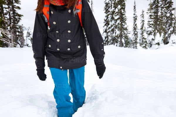 Woman in Outdoor Clothing Walking Through Deep Snow