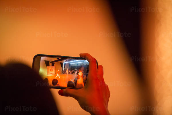 Woman Taking Picture of a Dance Competition with a Camera Phone