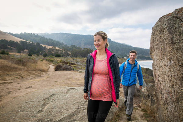 Pregnant Woman and Her Husband Hiking on a Coastal Trail