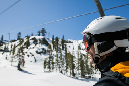 Close-Up of a Male Skier Sitting on a Chairlift 