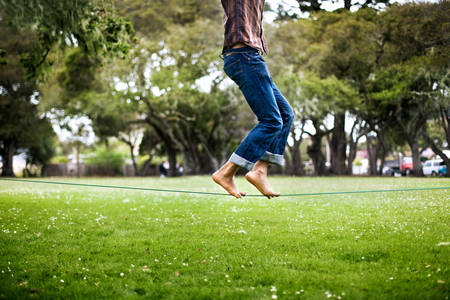 Man on His Toes Walking a Slackline in a Park