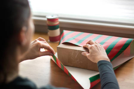 Woman Wrapping Christmas Presents on a Table