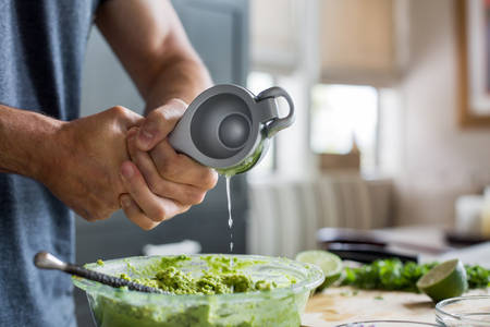 Man Squeezing a Lime into a Bowl with Guacamole