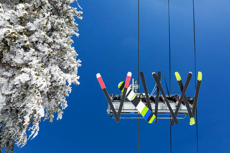 Straight-Up View of Skiers and a Snowboarder on a Ski Lift
