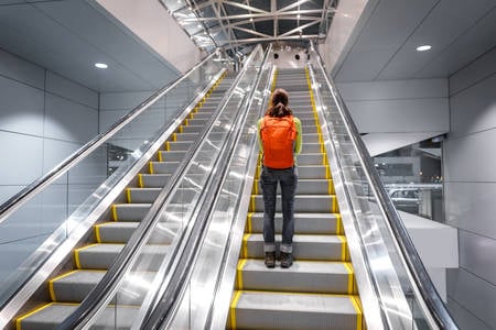 Woman Going up an Escalator at the Airport