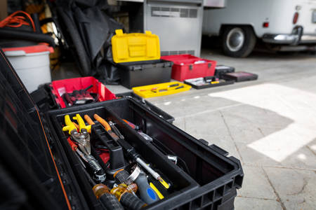 Toolboxes with Various Tools in Front of a Garage