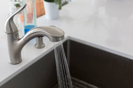 Close-Up View of a Kitchen Faucet with Running Water