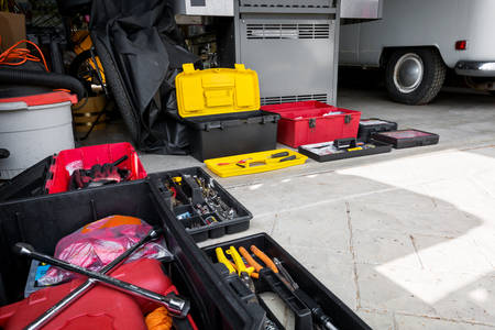 Open Toolboxes with Various Tools in Front of a Garage