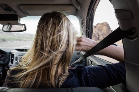 Rear View of a Woman in a Car with Hair Blowing in Wind