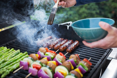 Man Braising Sausages on a Bbq Grill in a Garden