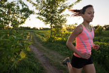 Young Athletic Woman Running on a Trail During Sunset Young Athletic Woman Running on a Trail During Sunset