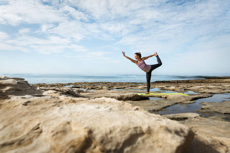 Young Woman Practicing a Yoga Dancer Pose by the Ocean