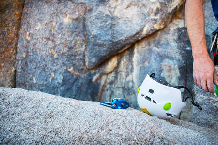 Rock Climber's Helmet and Belaying Device Laying on a Granite Slab