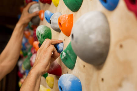 Male Climber Gripping Holds on a Training Wall at Home