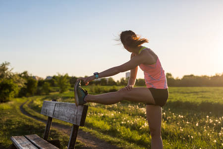 Athletic Woman Stretching Before an Evening Trail Run