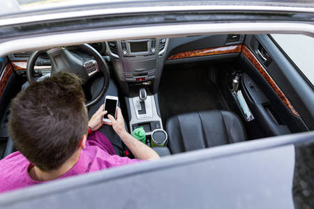 Overhead View of a Car Interior with a Man Using a Cell Phone