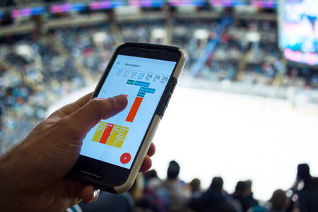 Man Using His Cell Phone During Ice Hockey Game