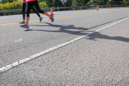 Low-Angle View of Two Marathon Runners on a Road
