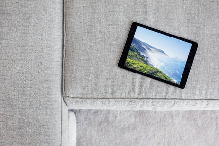 Directly-from-Above View of a Digital Tablet on a White Sofa