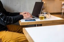 Web Developer Working Remotely on a Laptop in a Cafe Web Developer Working Remotely on a Laptop in a Cafe