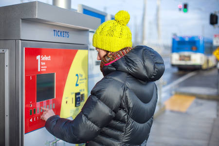 View of a Woman Buying a Bus Ticket at Public Transport Platform
