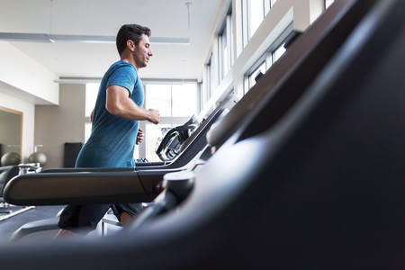 Man Jogging on a Treadmill in a Fitness Gym