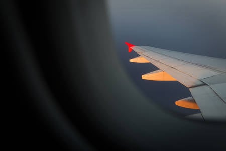 Airplane Wing Illuminated by Setting Sun Seen Through a Window