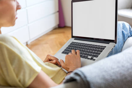 Young Woman in Casual Clothing Working on a Laptop from Home