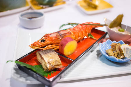 Japanese Culinary Meal with a Large Shrimp, Fish, and a Potato