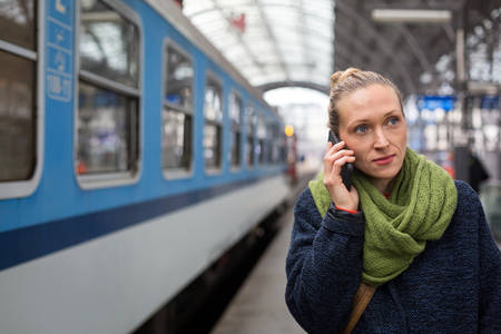 Woman Walking on a Railroad Platform and Making a Phone Call