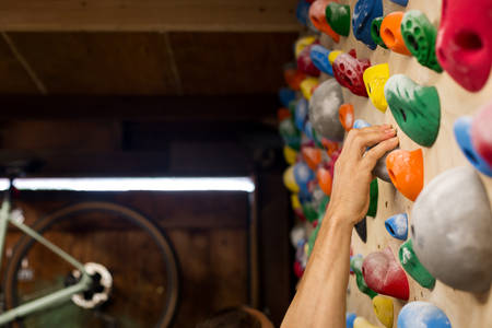 Man's Hand Gripping a Hold on a Practice Wall at Home