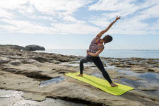 Young Athletic Woman Practicing Yoga by the Ocean
