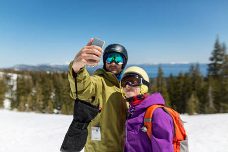 Couple in Winter Clothing Taking Selfie on a Ski Run 