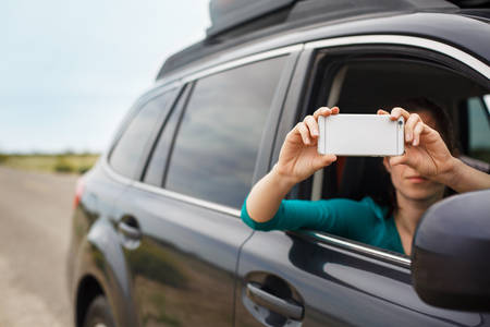 Woman Taking a Picture from a Car with a Cell Phone