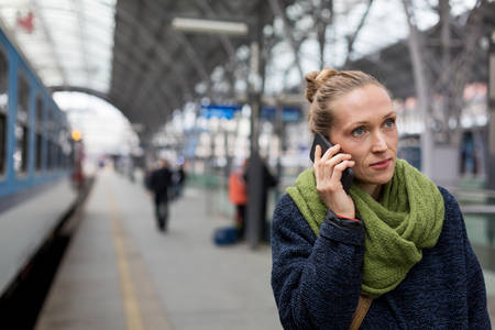 Woman Walking in a Train Station and Making a Phone Call