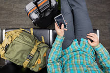 Overhead View of a Man Waiting at an Airport Using a Cell Phone Overhead View of a Man Waiting at an Airport Using a Cell Phone