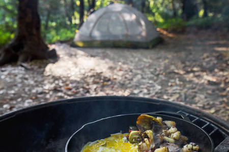 An Iron Skillet with Eggs and Potatoes on a Fire Pit in a Campground