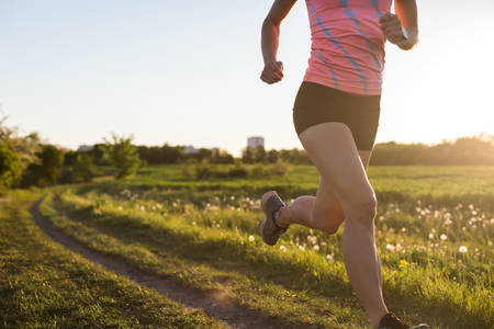 Athletic Woman Jogging on a Trail During Sunset