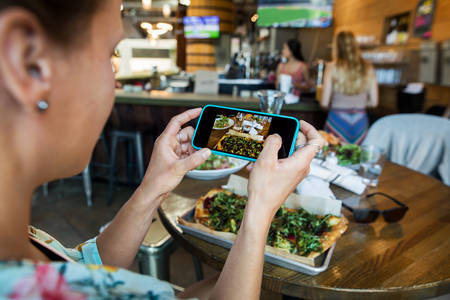 Woman Taking Picture of Her Meal with a Cell Phone