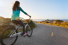 Girl on a Late Afternoon Cruiser Bike Ride on an Ocean Coast Girl on a Late Afternoon Cruiser Bike Ride on an Ocean Coast