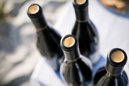 High-Angle View of Wine Bottles Placed on a Table with a White Tablecloth