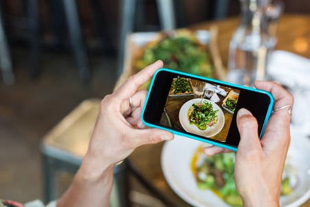 Hands of a Woman Taking a Picture of a Meal with a Smartphone