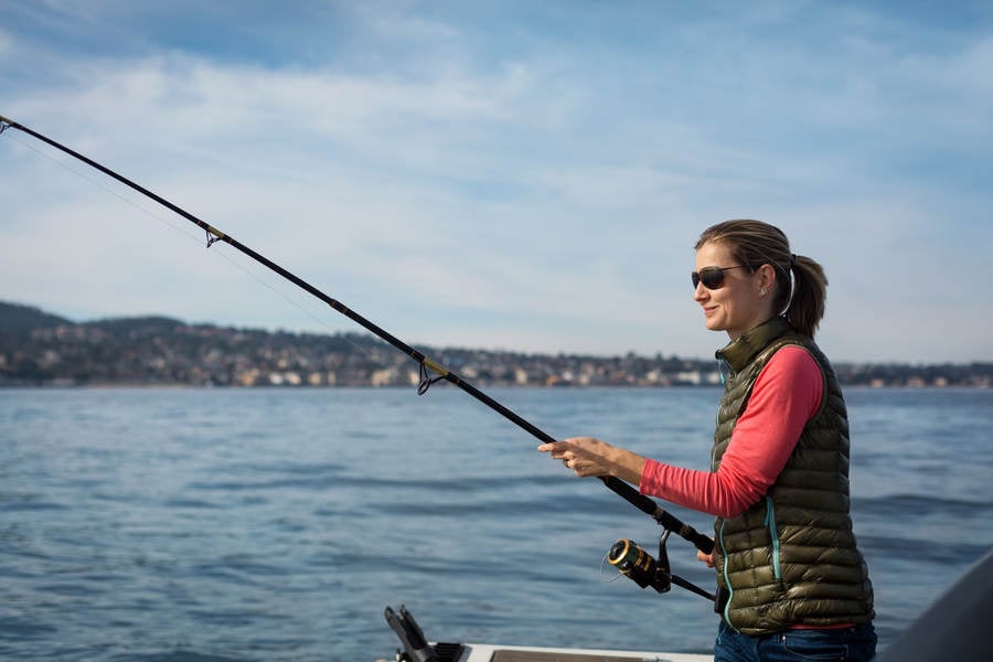 Smiling Woman Fishing from a Stock Photo - PixelTote