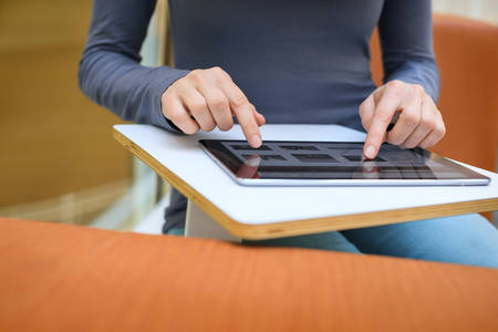 Low-Level View of a Woman Typing on a Digital Tablet