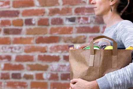 Close-Up of a Woman Carrying a Paper Bag with Groceries