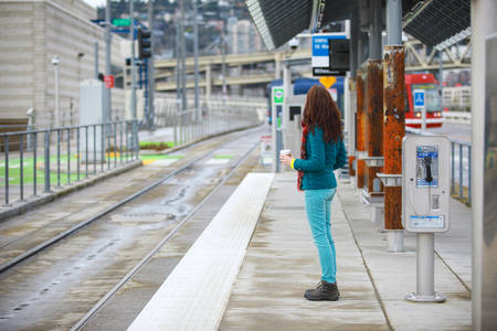 Woman Waiting for a Train on a Public Transportation Platform