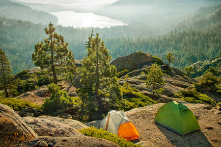 Two Tents Pitched on a Ledge Overlooking a Valley with a Lake